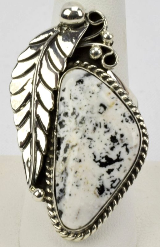 Navajo Sterling White Buffalo Turquoise Ring-Tahe: Measures 1.75 inches long with a Natural White Buffalo Turquoise Center Stone. The Stone is accented with feather and bead design. Marked Sterling and Hallmarked on the back. Has script signature "Tah