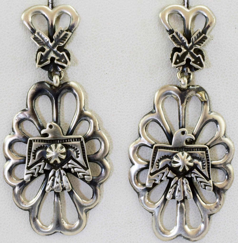 Navajo Sterling Silver Thunderbird Earrings: For pierced ears these measure 2.25 inches and have a polished sand cast look to them. The top portion has crossed arrows and the bottom sections have the Thunderbird in the center. Marked Sterling an