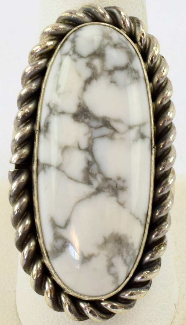 Navajo, Ben Begaye White Buffalo Turquoise Ring: Measures 1 5/8 inches long with White Buffalo Turquoise {howlite} across the top accented with a rope frame. Inside marked Sterling and Signed "Begaye". Weighs 19.7 Grams and is a Size 9.5. Native Ame