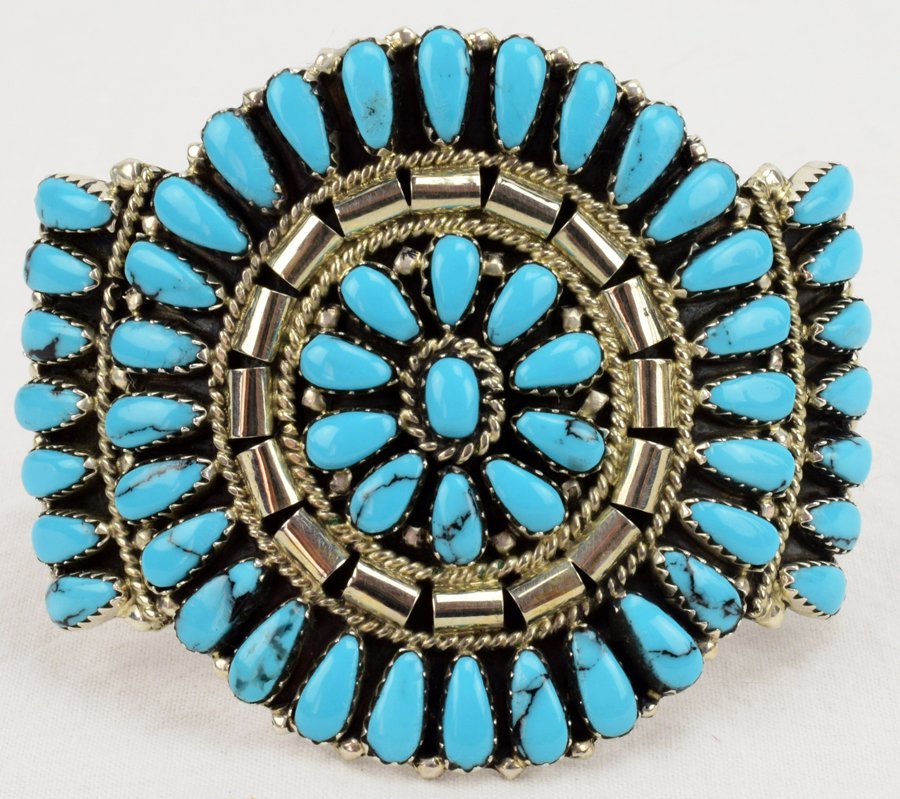 Navajo Sterling Turquoise Cluster Cuff-Juliana Williams: We were sad to hear of this Artist's passing so don't miss this. Measures 2 1/8 inches in diameter and is done in a cluster style with Block Turquoise accented with a Sterling rope design. The inside 