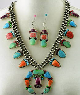 Geraldine James Multi-Stone Squash Blossom Necklace set: Measuring 25+ inches in length without the Naja drop this necklace has Stones of Green and Blue Turquoise, Orange and Purple Spiny Oyster and Coral. The blossoms are Gemstones with a halo of accenting