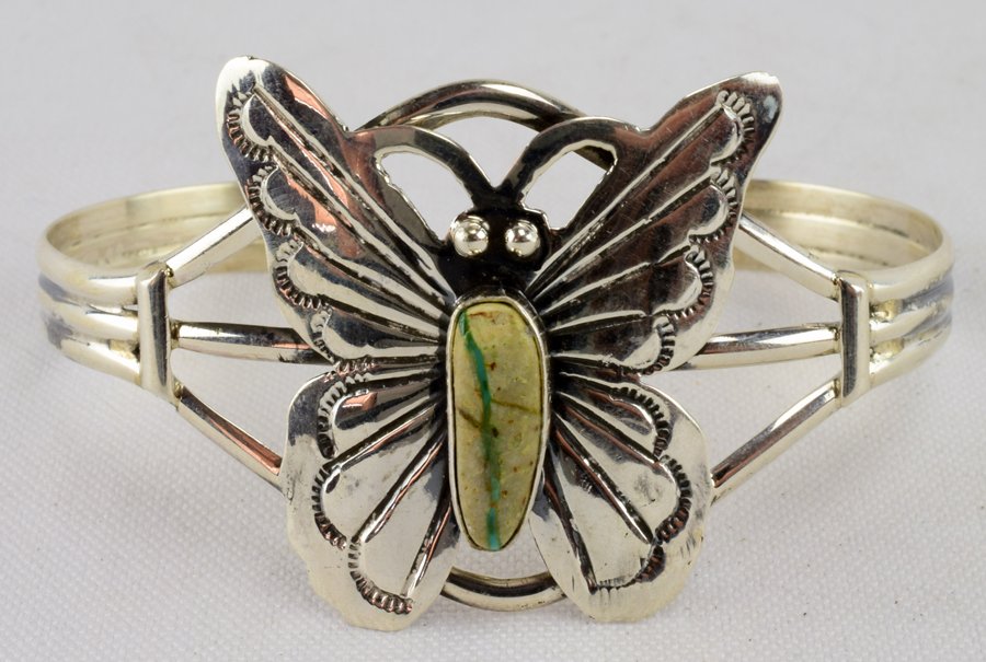 Navajo Sterling and Turquoise Butterfly Cuff: A dainty sterling silver silver with a beautiful turquoise stone.Weighs 15.8 grams.Measures 5-1/2" inside with a 1-1/2" gap.(7" total.There is plenty of play for careful size adjustments.Marked Sterli