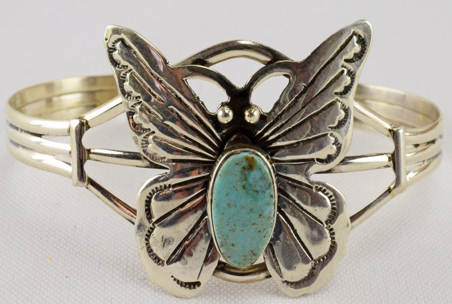 Navajo Sterling and Turquoise Butterfly Cuff: A dainty sterling silver silver with a beautiful turquoise stone. Weighs 15.8 grams. Measures 5-1/2" inside plus a 1-1/2" gap.(7" total. There is plenty of play for careful size adjustments. Marked St