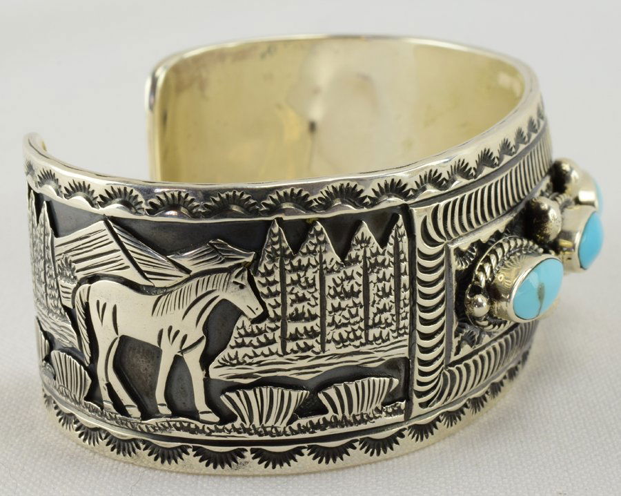 Navajo Sterling Horse Storyteller Cuff W/Turquoise: Done in a Storyteller style with Turquoise stones in the center this piece measures 1 inch wide all around with the entire piece being hand stamped. Inside measures 5 5/8 inches plus a gap of 1 1/8 in
