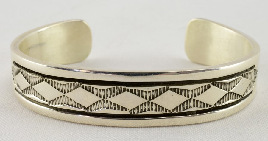 Navajo Heavy Stamped Sterling Cuff-Bruce Morgan: Measures 1/2 inch wide all around with deep grooved stamped design with that this artist is famous for. The inside measures 5.75 inches plus a gap of 1.25 inches. The piece is even decorated on the in