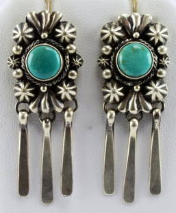 Navajo Sterling Silver Dangle Turquoise Earrings: Measuring 2 inches long x 3/4 inch wide with a Natural Turquoise Center stone. The earrings have Star Conchos and bead design with dangles below. Stamped Sterling and Hallmarked with a Half Moon