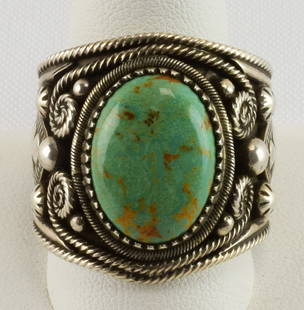 Blue Gem Turquoise Cabochon Men's Ring by Richard Jim: This is a very well made and has a low profile for busy hands. It measures 1 inch wide with a Nevada Blue Gem Turquoise Cabochon Center Stone. The stone is bezel set with Scroll, Bead and Hand applied