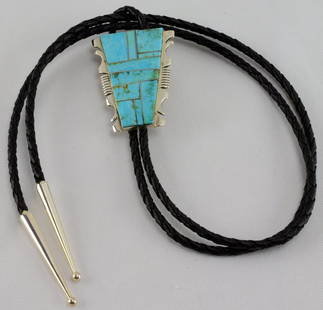 Navajo Sterling Kingman Turquoise inlay Bolo Tie: Measuring 2 inches long x 1.75 inches wide this piece has inlay of Kingman Turquoise in a Sterling Notched Frame. The braided leather is approx. 36+ inches in length and has small Sterling End