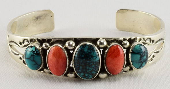 Leroy James Sterling Turquoise and Spiny Oyster Bracele: Measuring 1/2 inch wide this piece has oval Cabochons of Natural Turquoise and Spiny Oyster alternating across the top.. The stones are accented with a bead design and stamped band. Inside measures