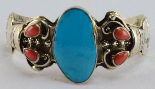 Navajo Sterling Turquoise & Coral Pottery Bracelet: Measures 1.25 inches wide with a Natural Turquoise Center stone that is accented on each side with two coral pieces. The band has a hand applied "jug" or pottery piece and hand stamp work. Inside meas