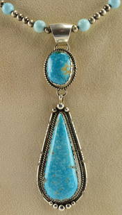 Elouise Kee Sterling Fox Turquoise Pendant: Measuring 3.75 inches from Bale to bottom. This pendant is done in a Tear Drop shape with an oval Turquoise Stone at the top. The Turquoise is from the Fox Mine. A simple setting with small rope and b