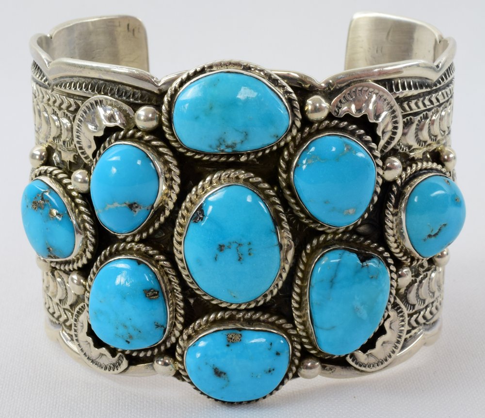 Navajo, Tillie Jon Sleeping Beauty Turq. Huge Bracelet: Measuring 2 inches wide all around this is a fantastic piece. It has a band that is completely hand stamped and in the center there are 9 Sleeping Beauty Turquoise polished Stones. Th stones are set i