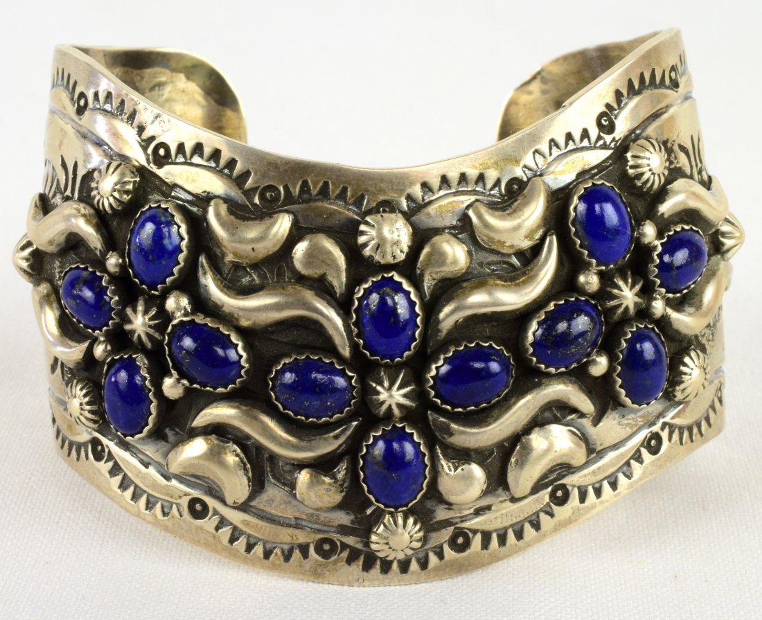 Marcella James Sterling Wide Repousse Lapis Bracelet: Measures 1.5 inches long and done in a Cheveron style with Repousse and stamp design work. This bracelet is done in an older style and hangs below the sleeve line. Adorned with Lapis cabochon pieces a