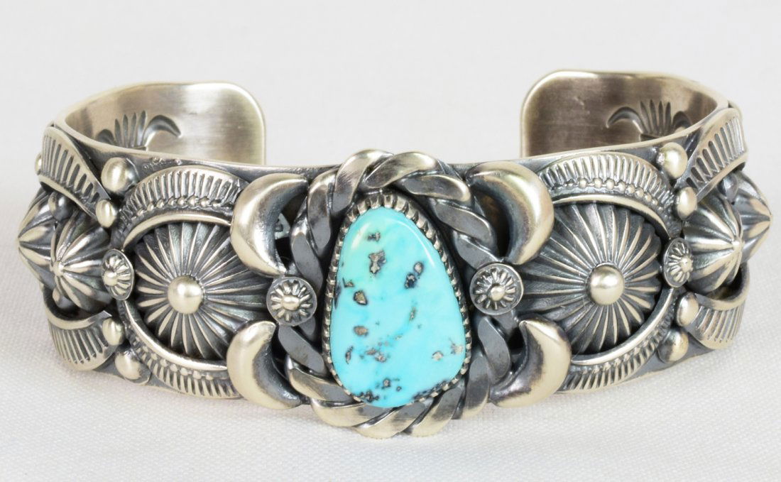 Delbert Gordan Kingman Turquoise Heavy Applique Cuffel: This bracelet measures 1.25 inches wide and was made by one of the Master Silversmiths who draws and fabricates his own designs. The cuff has a Natural Kingman Turquoise Center stone and is adorned wi