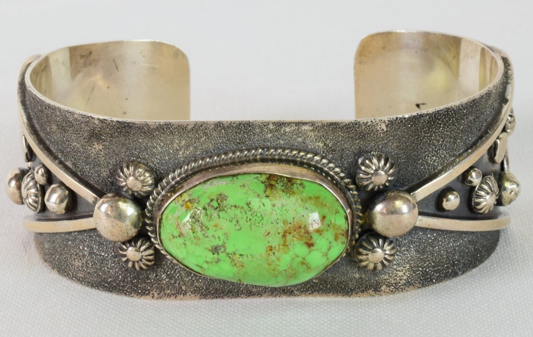 Navajo Sterling Orvil Jack Turquoise Bracelet: Measures 1 inch wide with a Domed Natural Turquoise Center stone from the Orvil Jack Turquoise mine. The band is accented with various bead designs in Celestial style with a textured Grey background. 