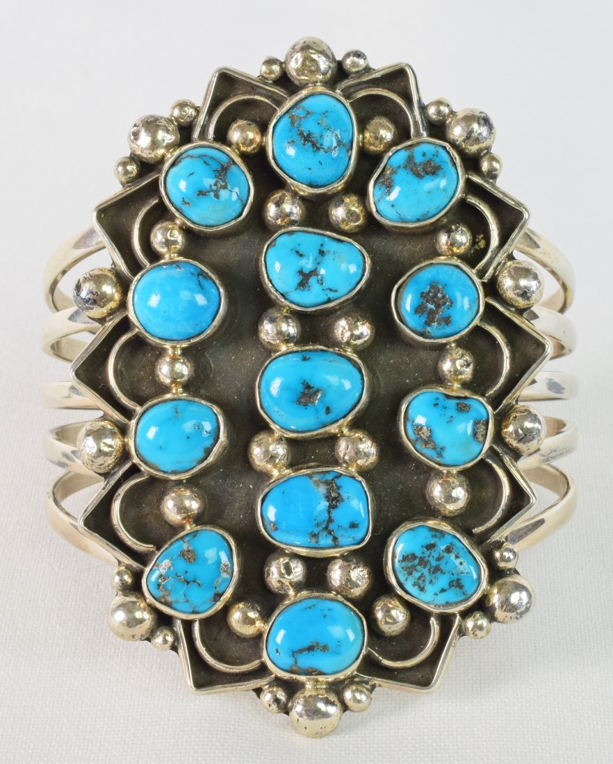 Native American Sterling Morenci Turquoise Bracelet: Measuring 3.25 inches long this bracelet has Bright Blue Morenci Turquoise stones that are randomly bezel set with Shiny Sterling beads on a black background. The piece has a zig-zag edge to further e