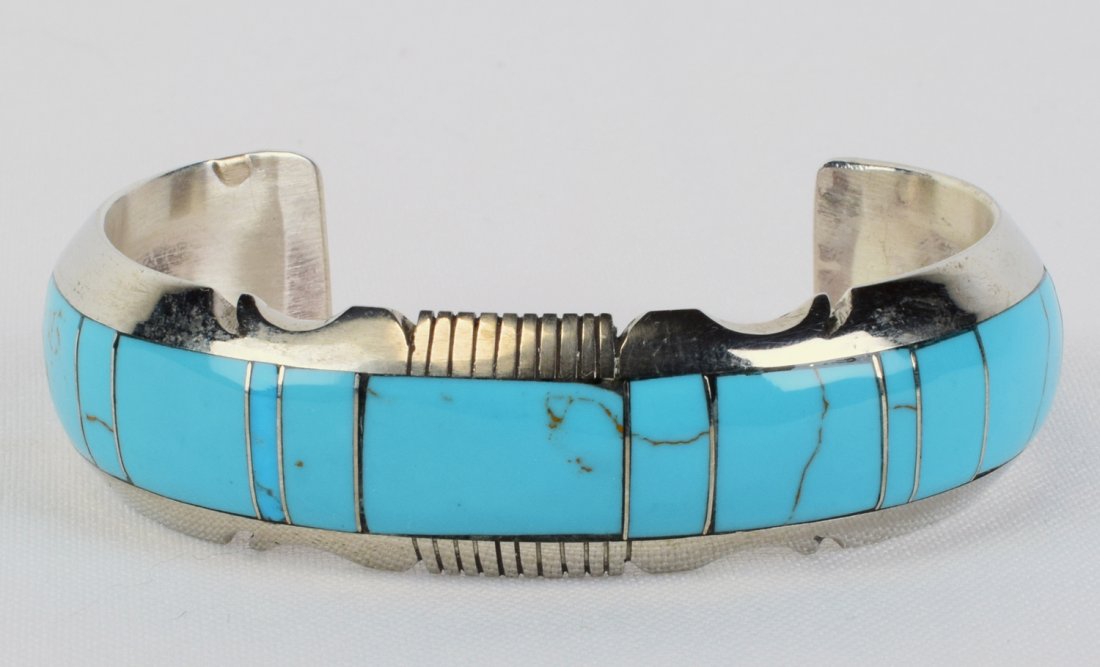 Steve Francisco Sterling Block Turquoise Inlay Bracelet: Measures 3/4 inch around this piece is hand inlaid with {block} turquoise throughout. The piece has a notched and polished frame. Inside measures 5.25 inches plus a gap of 1.5 inches. Stamped Sterling