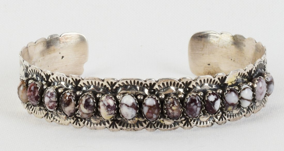 Lorenzo James Sterling Wild Horse Turquoise Cuff: Measures 1/2 inch wide. This piece has 15 Polished Wild Horse Turquoise Cabochon Stones across the top with a bead and stamped band accent. Great to wear alone or stack. Inside measures 5.5 inches plu