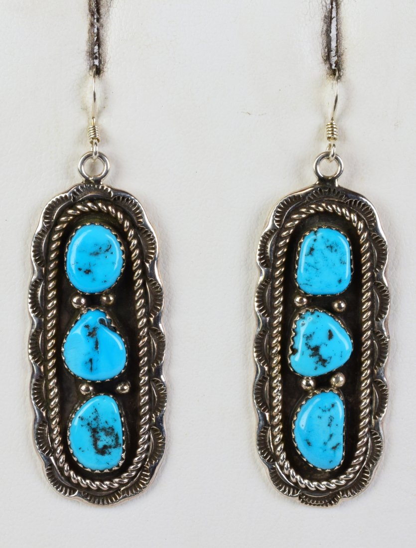 Julia Etsitty Kingman Turquoise Nugget Earrings: Measures 2.5 inches long these earrings have beautiful blue Natural Turquoise stones in the center with a bead and scallop frame. They have 3 piece of free form turquoise in each piece. Stamped Sterli