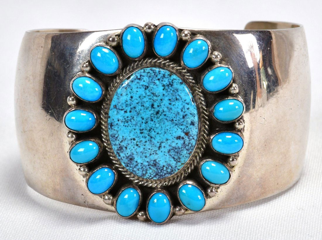 Navajo Sterling Blue Gem Turquoise Wide band Bracelet: Measures 1.75 inches wide in the center and tapers to 1.25 inches at the opening. This piece had a High Grade Blue Gem Turquoise Center stone and is accented with Halo pieces It is finished in a brigh