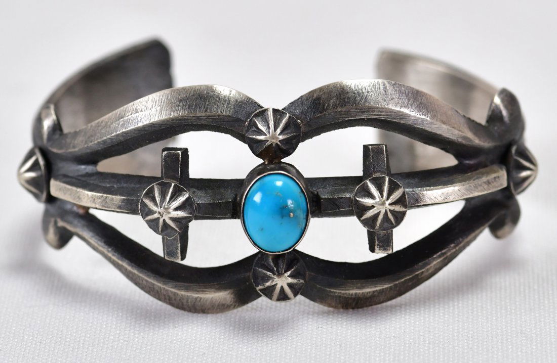 Chimney Butte Sterling Sand Cast Bracelet w/Turquoise: Measures 1.25 inches wide and done in a Sand Cast Style. This piece has a Natural Turquoise Center stone and star concho designs. Inside measures 5.25 inches plus a gap of 1.25 inches. Stamped Sterlin