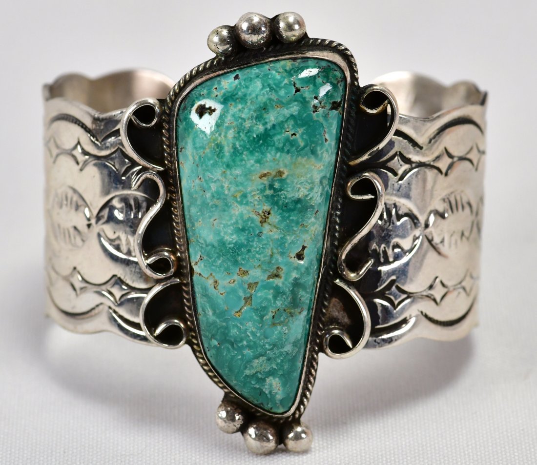 Chimney Butte Sterling Nevada Turquoise Bracelet: Measures 2.5 inches wide with a Natural Turquoise Center Stone accented with scroll and bead design work. The band is a bright polished sterling and completely hand stamped. Sterling Silver/Signed and