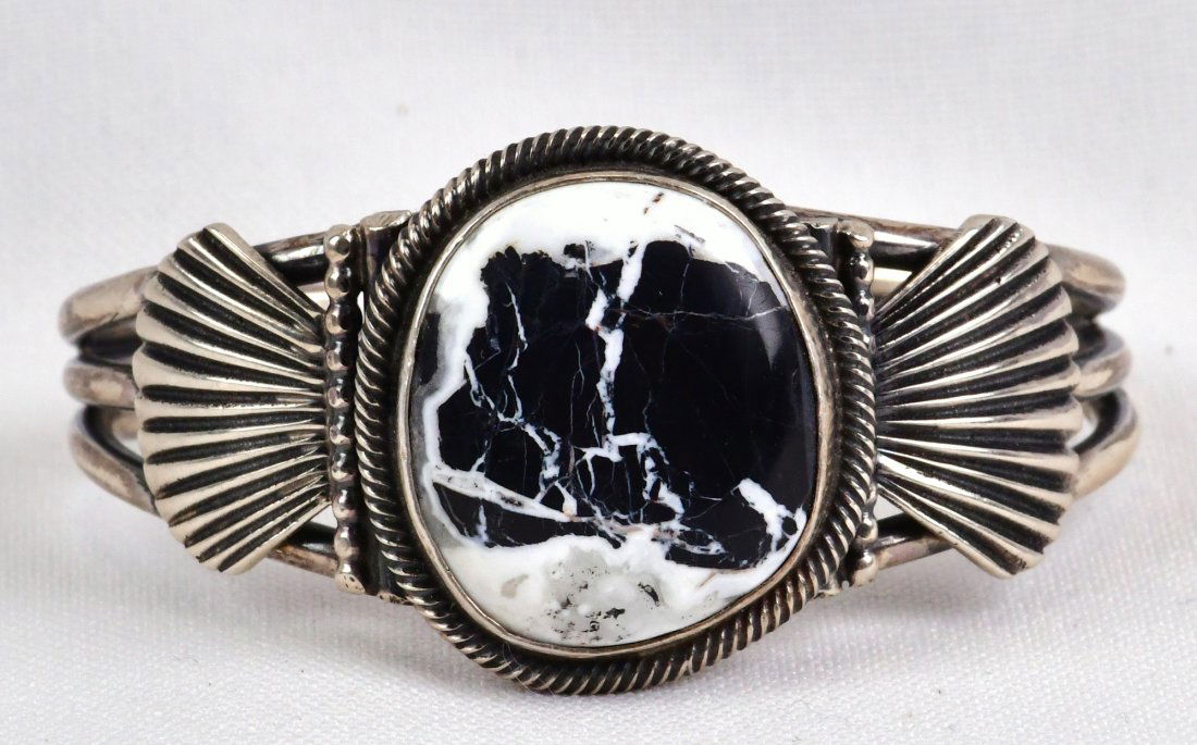 Leon Martinez Sterling White Buffalo Turquoise Bracelet: Measures 1.25 inches wide. This piece is well made and has applied Sterling Shell pieces accenting the center stone. Inside measures 5 inches plus a gap of 1.25 inches. This with fit a 6-6.5 inch wris