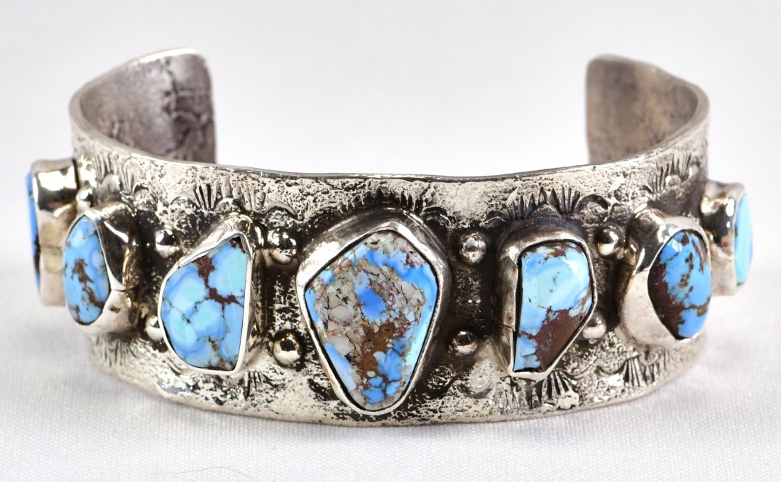 Jude Candeleria Sterling Golden Hills Turquoise Bracelet: Sterling Silver| Jude Candeleria Sterling Golden Hills Turquoise Bracelet| Genuine Golden Hills Turquoise| Inside measures 5.75" plus a gap of 1.5" - Total 7.25"| Face Width 1.25"| Signed| Weighs 68.6