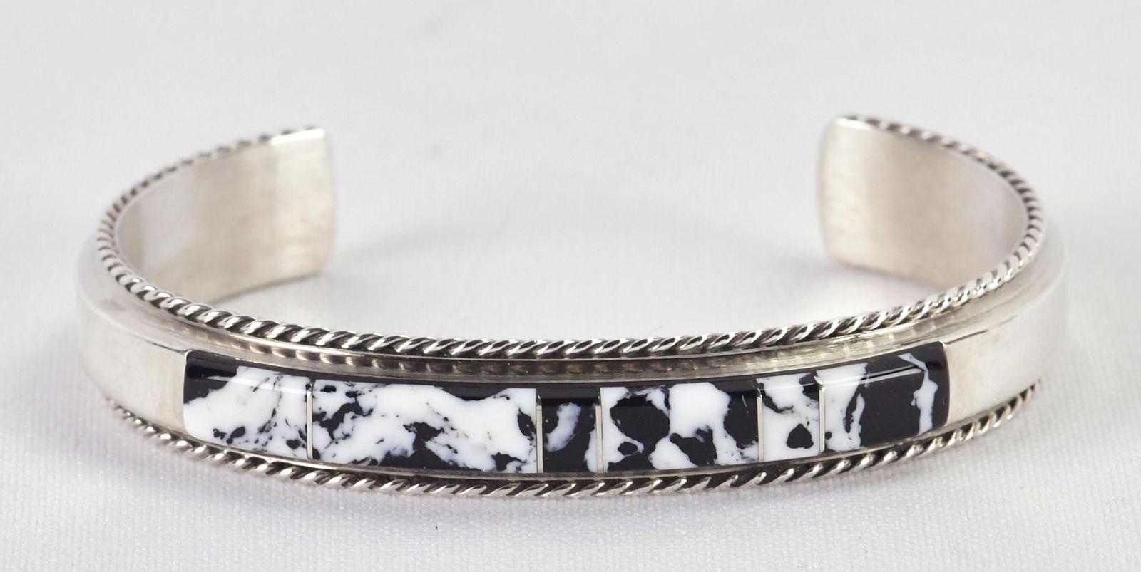 Navajo Sterling Silver White Buffalo Turquoise Inlay Cuff Bracelet: Sterling Silver| Navajo Sterling Silver White Buffalo Turquoise Inlay Cuff Bracelet| Genuine White Buffalo Turquoise| Inside measures 5.25" plus a gap of 1.25" - Total 6.5"| Face Width 1/4"| Hallmarke