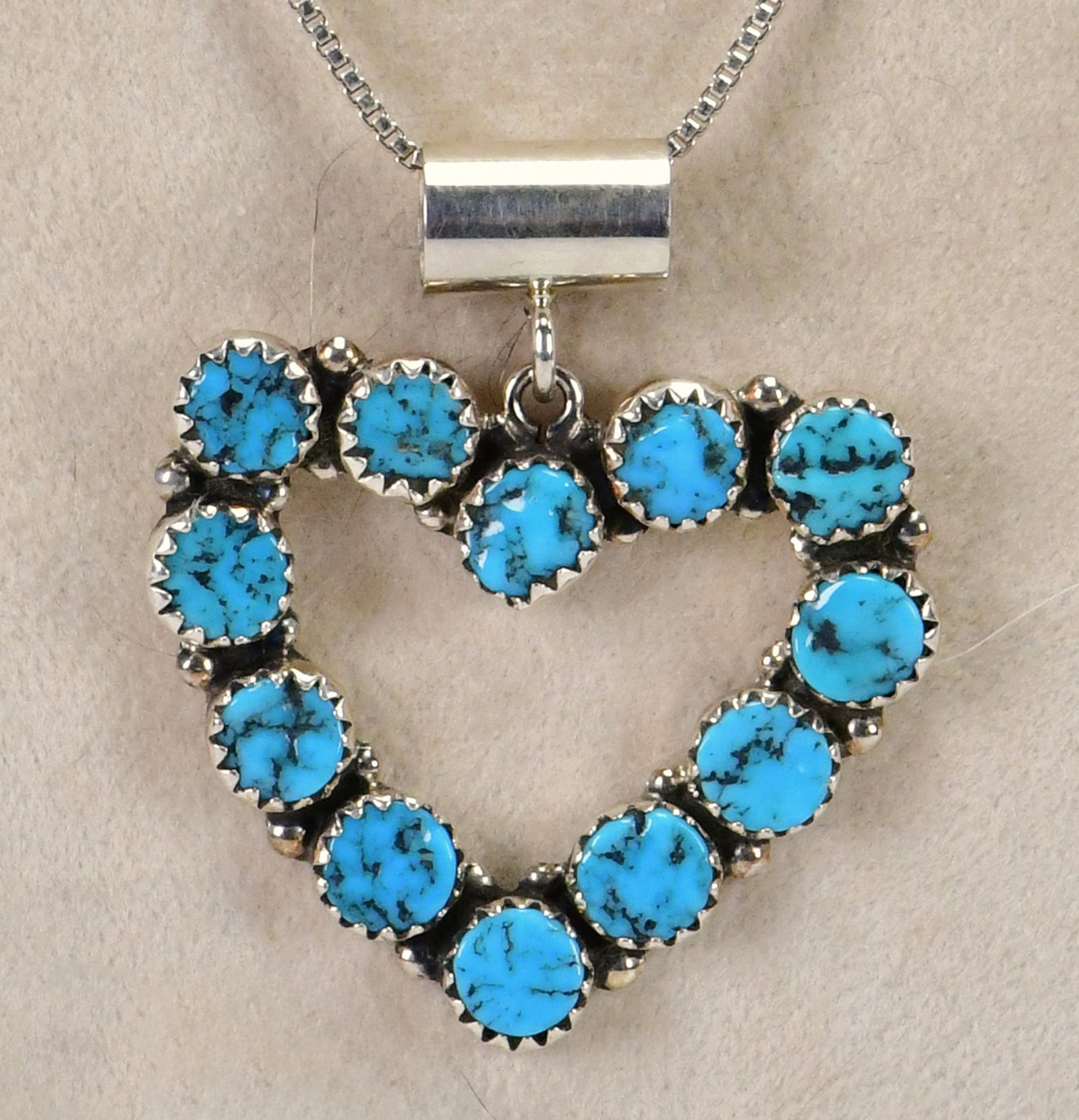 M. L. Perry Sterling Kingman Turquoise Seafoam Heart Pendant Necklace: Sterling Silver| M. L. Perry Sterling Silver Kingman Turquoise Seafoam Heart Pendant Necklace| Genuine Seafoam Kingman Turquoise| Comes with 18" Box Length Chain| Pendant measures 1.5" Long x 1.25" Wi