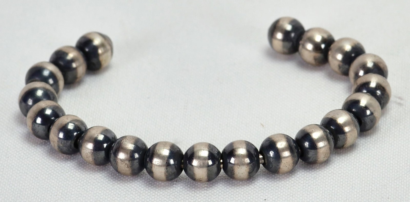 Native American Sterling Navajo Pearls Polished Cuff Bracelet: Sterling Silver| Native American Sterling Navajo Pearls Polished Cuff Bracelet| All Sterling Silver| Inside measures 5.25" plus a gap of 1.25" - Total 6.5"| Face Width 3/8"| Navajo Pearls are 8 mm in