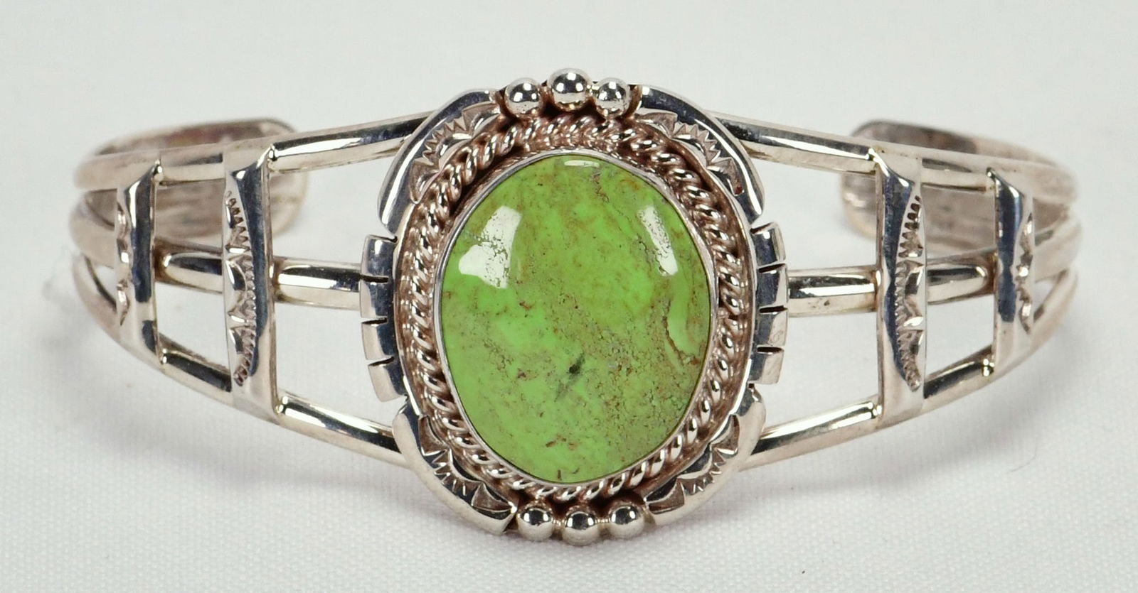 Navajo Sterling Silver Gaspeite Cuff Bracelet: Sterling Silver| Navajo Sterling Silver Gaspeite Cuff Bracelet| Genuine Gaspeite| Inside measures 5.5"plus a gap of 1.5"- Total 7"| Face Width 1.25"| Hallmarked with an "Arrow" and "SV"| Weighs 28.3 G