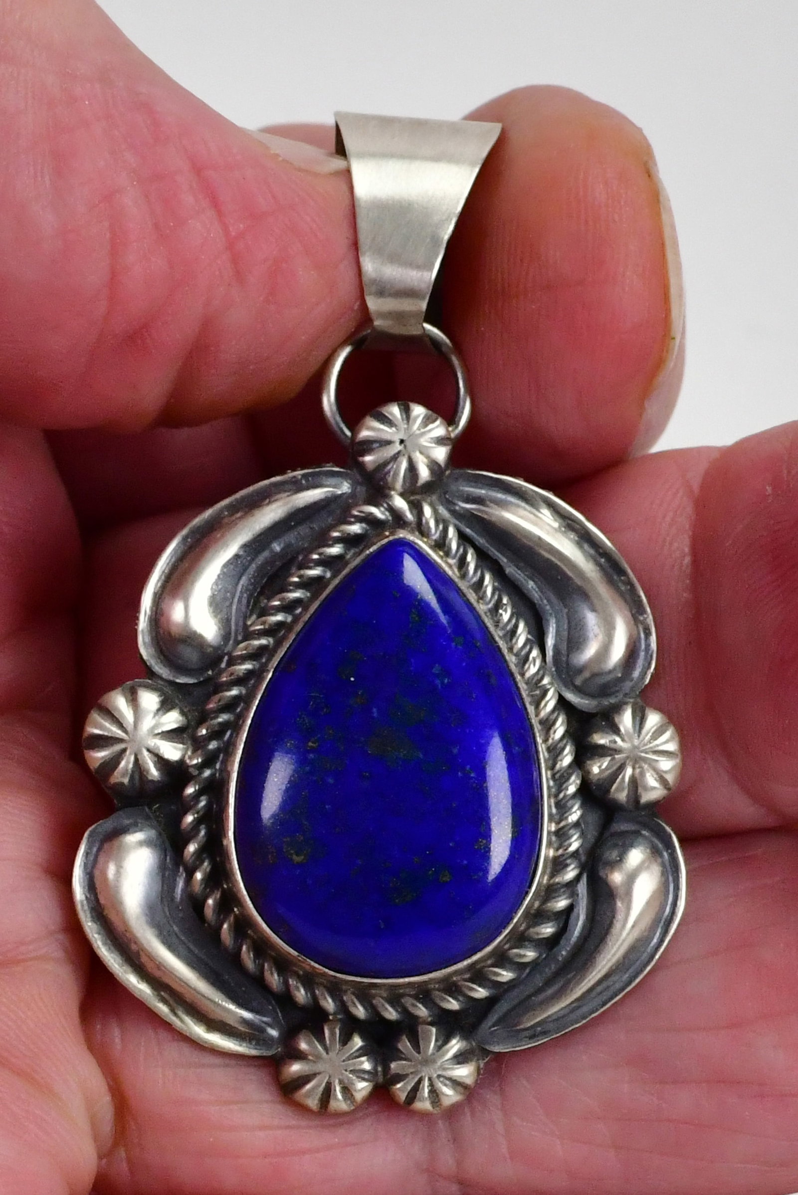 Jeff James Jr., Navajo, Sterling Silver Lapis Lazuli Pendant w/Ornate Frame: Pendant Only - Sterling Silver| Jeff James, Jr. Sterling Silver Lapis Lazuli Pendant w/Ornate Frame| Genuine Lapis Lazuli| Measures 2.25" Long x 1.5" Wide| Hallmarked "JJJ"| Has Repousse Sterling Orna