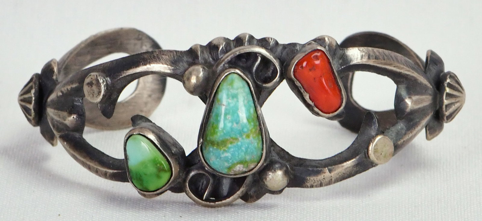 Chimney Butte Sonoran Gold Turquoise and Coral Sand Cast Bracelet: Sterling Silver| Chimney Butte Sonoran Gold Turquoise and Coral Sand Cast Bracelet| Genuine Sonoran Gold Turquoise, Genuine Coral| Inside measures 5.25" plus a gap of 1"- Total 6.25"| Face Width 1"|Si