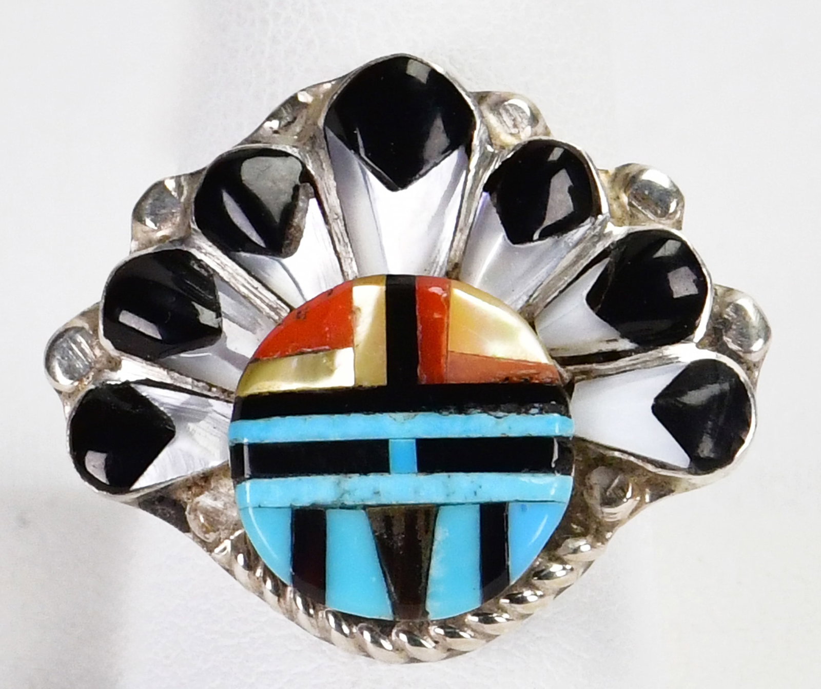 Native American Sterling Silver Multi-Stone Sun Face Ring - Size 9.75: Sterling Silver| Zuni, Native American Sterling Silver Multi-Stone Sun Face Ring| Genuine Turquoise, Spiny Oyster, Mother of Pearl and Jet| Measures 1" Long x 1.25" Wide| Hallmarked "MBG"| Weighs 7 Gr