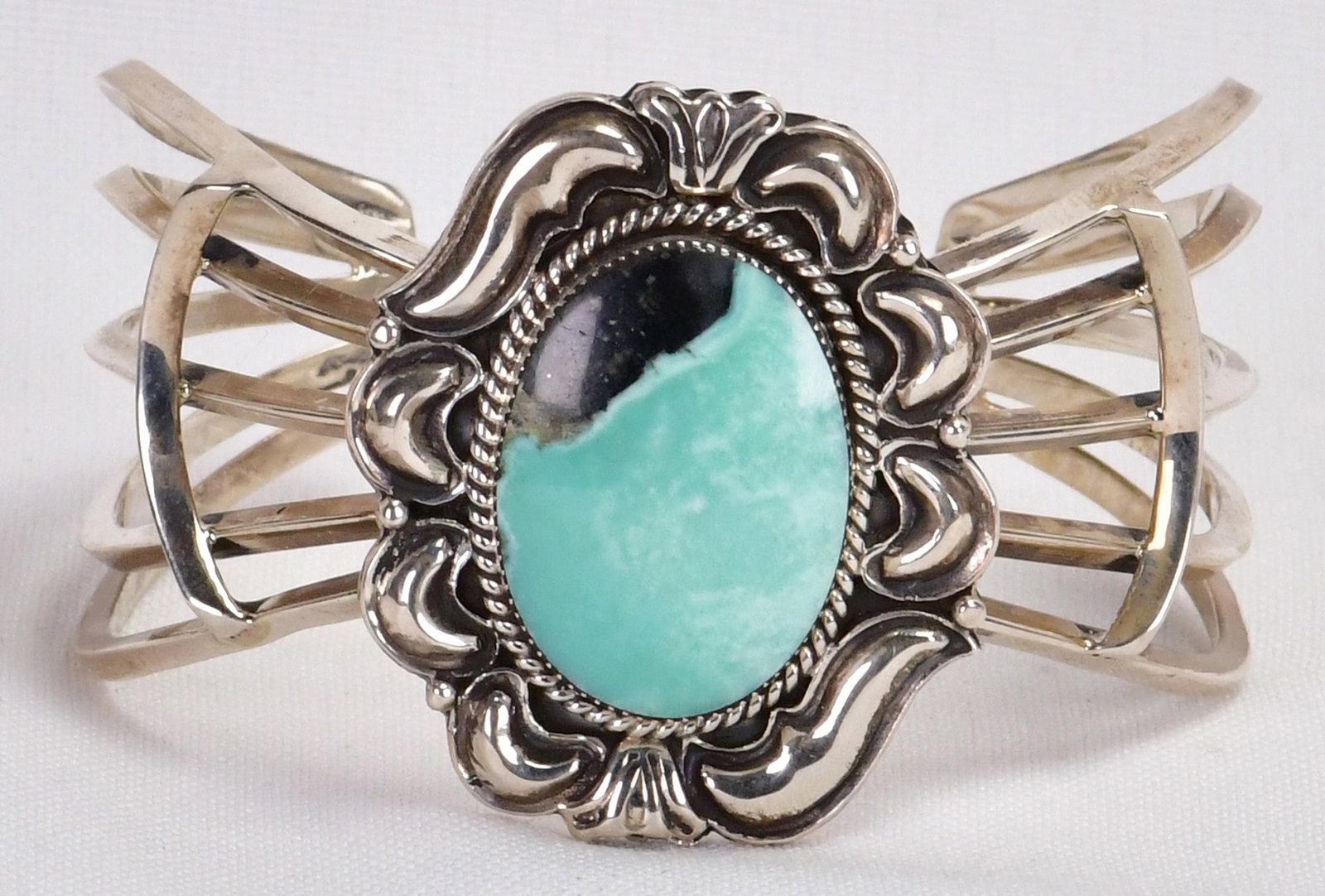 Navajo, Sterling Silver Nevada Turquoise Cuff w/Ornate Frame: Sterling Silver| Navajo, Sterling Silver Nevada Turquoise Cuff w/Ornate Frame| Genuine Nevada Turquoise| Inside measures 5.25" plus a gap of 1.25"- Total 6.5"| Face Width 1.75"| Has unique Repousse Fr
