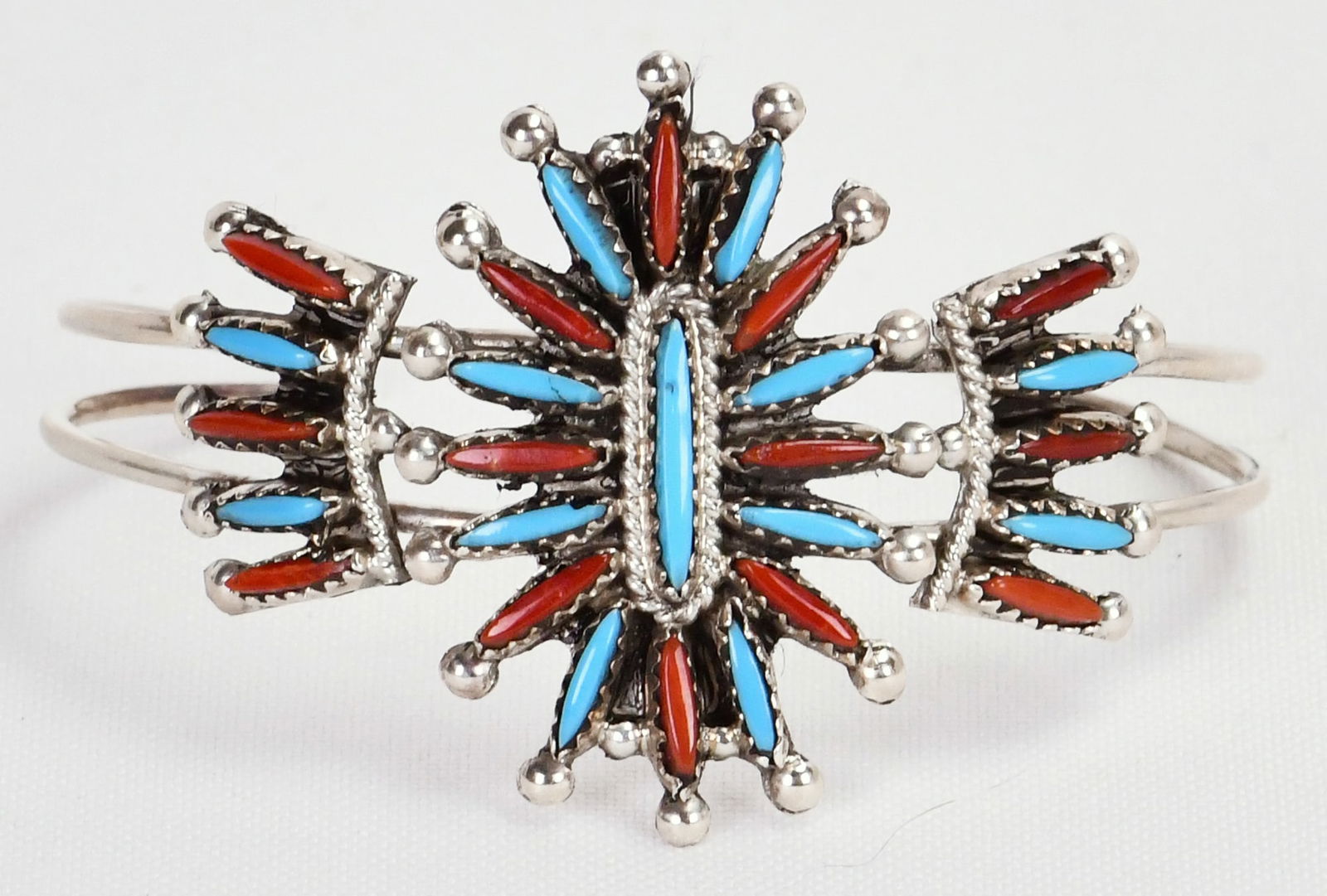 Zuni, Gerald Etsate, Sterling Silver Turquoise & Coral Sunburst Bracelet: Sterling Silver| Zuni, Gerald Etsate Sterling Silver Turquoise & Coral Sunburst Bracelet| Genuine Turquoise, Genuine Coral| Done in a Needlepoint style| Inside measures 5.25" plus a gap of 1.25" -Tota
