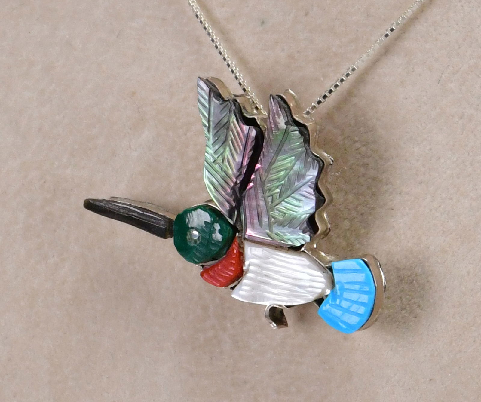 Zuni, Andrea Lonjose. Sterling Multi-Stone Inlay Hummingbird Pin/Pendant: Pin, Pendant Only - Sterling Silver| Zuni, Andrea Lonjose Sterling Silver Multi-Stone Inlay Hummingbird Pin| Genuine Turquoise, Abalone, Coral and Mother of Pearl| Measures 1.75" Wide x 1" Tall| Has c