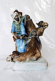 Amphora Porcelain Sculpture: Arab Beside a Pair of Camels 1920s: Art Nouveau Orientalist sculpture by Amphora Porcelain Works depicting an Arab man with the rifle beside two camels, polychrome painted and glazed. The underside with incised factory mark and impresse