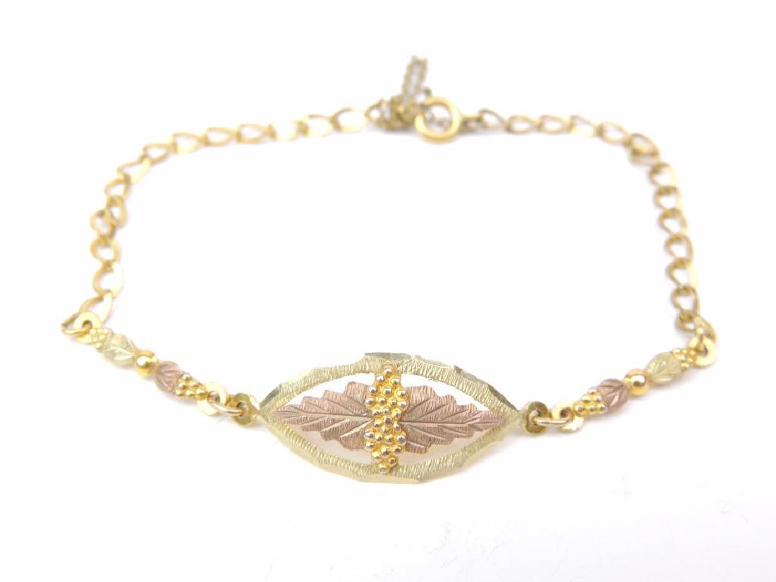 10K Black Hills Gold Bracelet: 10K Black Hills Gold 1" x 1/2" center and 3/4" side links. Chain that completes the bracelet is gold filled. Approx. length of the bracelet is 7" with a total weight of 3.3g