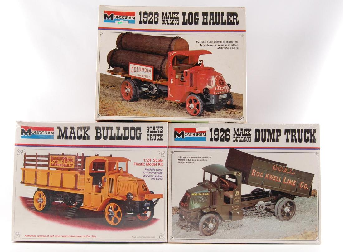 Group of 3 Monogram 1/24 Scale Truck Model Kits: Sealed Ringling Bros Mack Bulldog Stake Truck, Sealed 1926 Rockwell Lime Co. Mack Bulldog Dump Truck, and 1926 Columbia Lumber Co. Mack Bulldog Log Hauler.