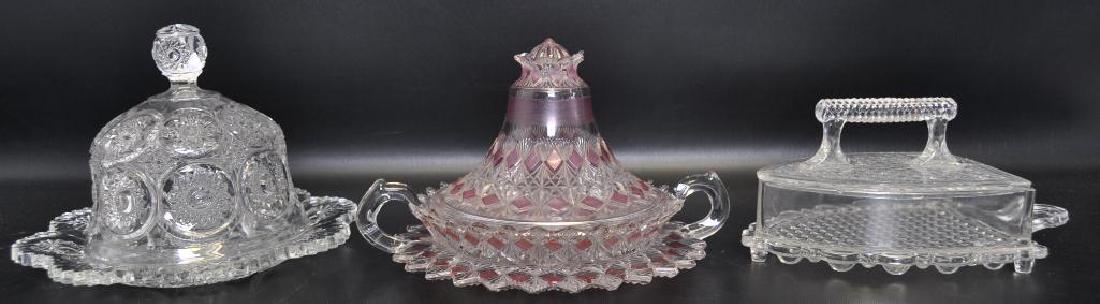 Group of 3 American Pattern Glass Covered Butter Dishes: Larger covered butter dome measures 8 x 6 inches. Both butter domes are in attractive vintage condition without chips. The covered iron shaped Indiana Glass butter dish measures 4 x 8 x 4 1/2 and has