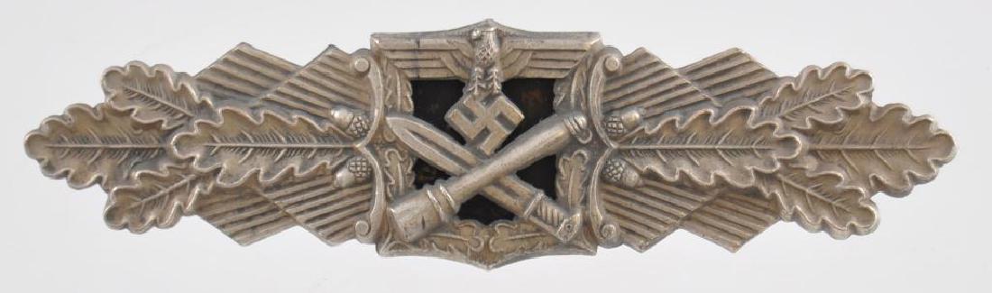WW2 German Army Silver Close Combat Clasp: The front shows an army eagle with a crossed stick grenade and bayonet below. All three are flanked by oak leaves on each side. The reverse side is maker marked JFS Fec W E Peekhaus Berlin . Has a wid