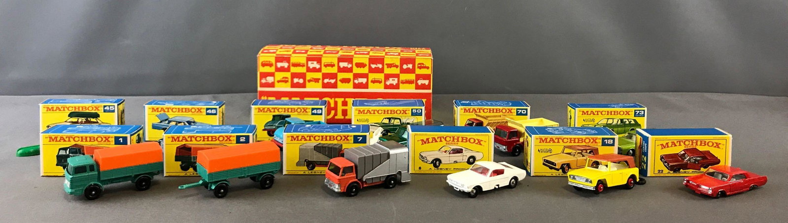 Group of 12 Matchbox Diecast Toy Cars in Gift Pack Box: Numbers 1, 2, 7, 8, 18, 22, 45, 46, 49, 50, 70, 73. In original gift pack box. Individual car boxes appear unopened. A Lesney Product.