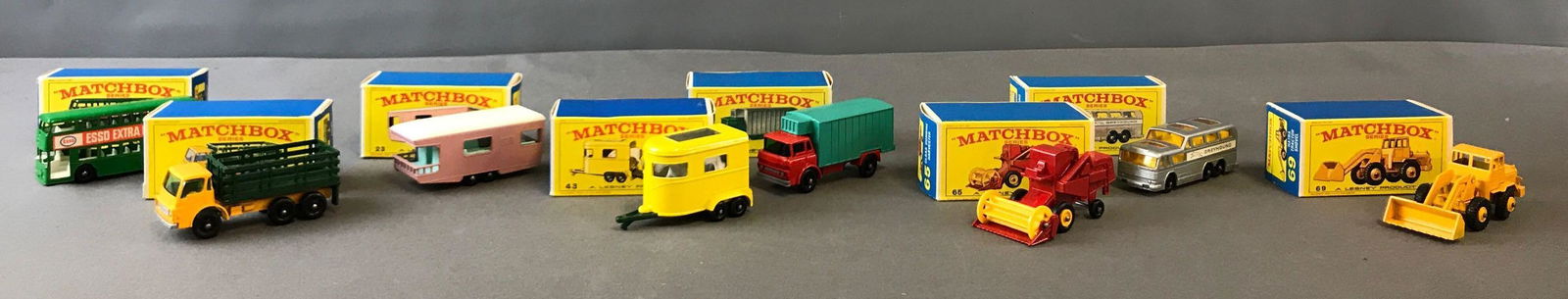 Group of 8 Matchbox Diecast Toy Cars: Trucks, Trailers,: A Lesney Product. Includes #44 Refrigerated Truck, 65 Combine Harvester, 4 Stake Truck, 69 Tractor Shovel, 43 Pony Trailer, 66 Greyhound Coach, 23 Trailer Caravan, and 74 Daimler Bus.