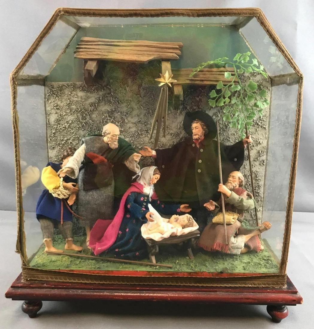 Vintage glass encased nativity: Glass case on wooden base. Adhesive on decorative trim has come loose in a few spots. 15.5 inches across, 16 inches tall and 6.25 inches deep