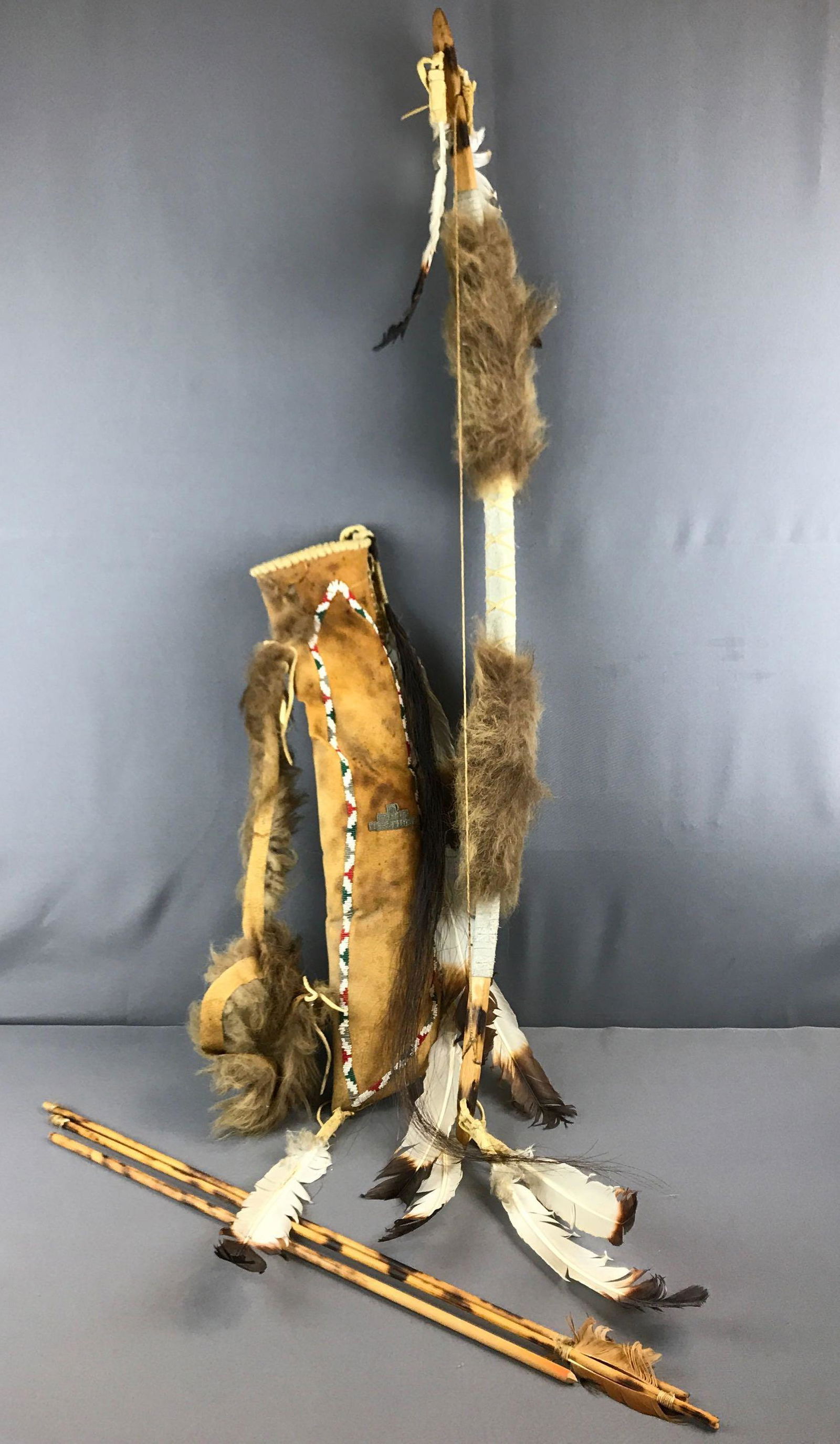 Native American Bow and Arrows: Navajo, bow is 46 inches long. Arrow holder is brittle and damaged toward the top. No arrowheads.