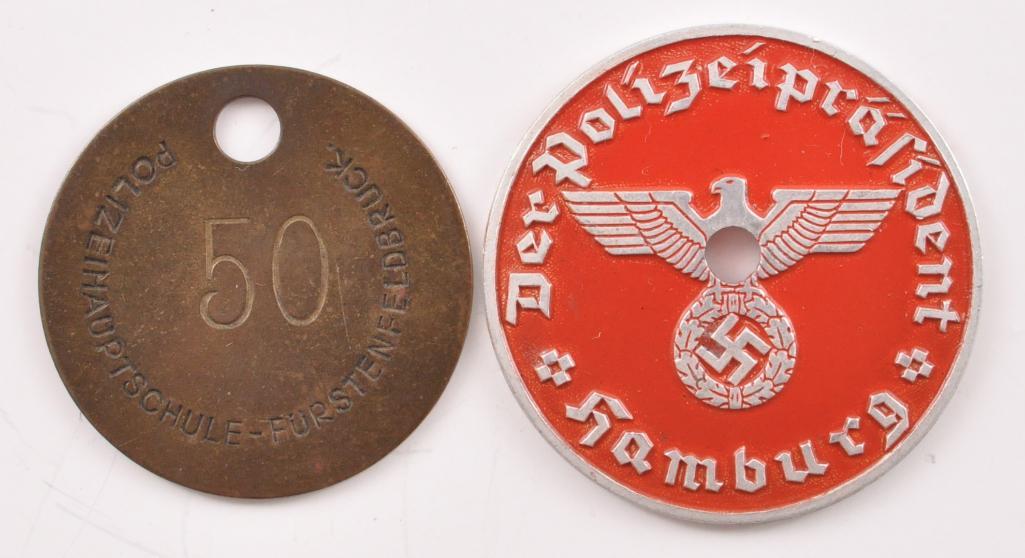 Group of 2 WW2 German Police Items: Includes #50 Key Fob for the Police School Furstenfeldbruck and Hamburg Police President License Plate ID Tag. Largest 1 1/2 inches round
