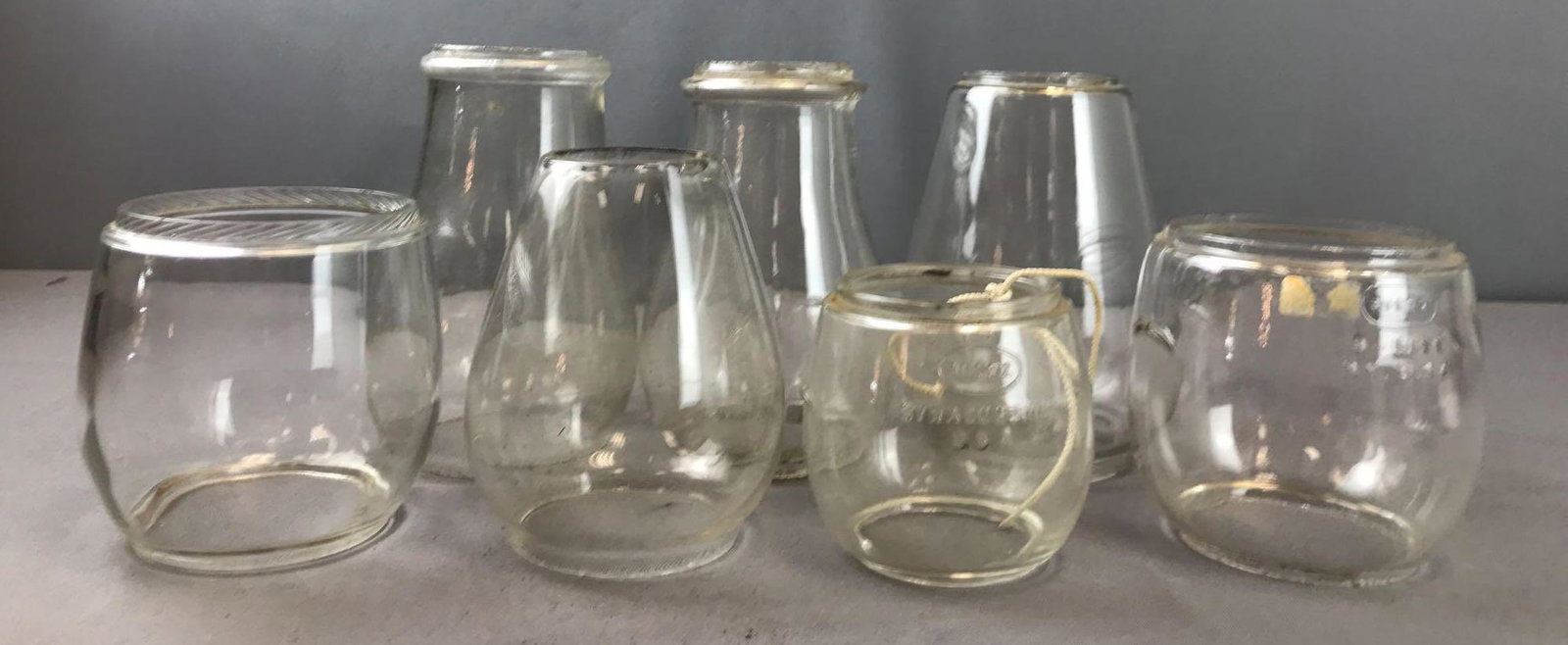 Group of 7 Clear Glass Globes: Largest is 7 inches tall. 2 embossed: Dietz D-Lite NY USA and Little Wizard Loc-Nob Recd U.S. Pat. Off.