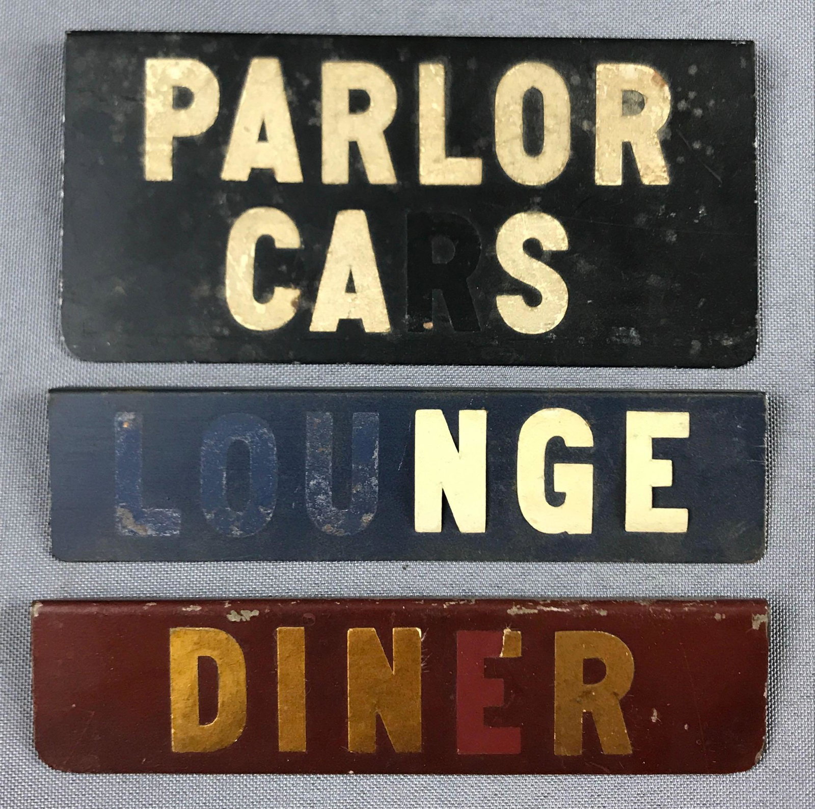 Group of 3 Vintage Pullman railroad/train car placards: Parlor cars, lounge, diner. Largest is 5.25x2.5 inches. Made of metal. Some letters are missing.